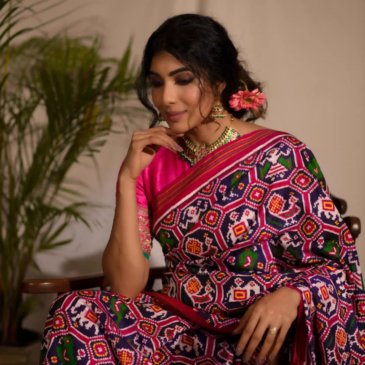 women sitting and posing in a pink patan patola saree